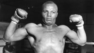 Jersey Joe Walcott poses and flexes his muscles