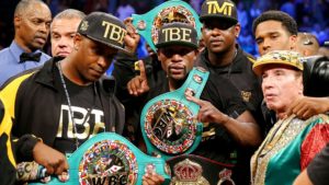 Floyd Mayweather celebrates a win with his championship belts and the rest of his team
